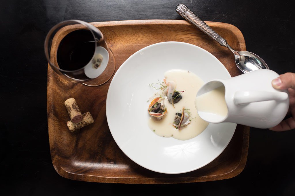 sirviendo sopa gourmet con copa de vino